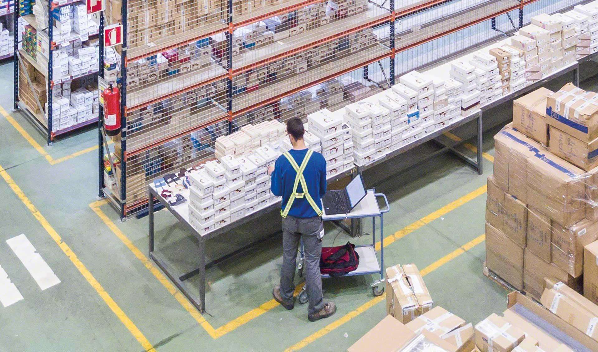 一名工人在电子设备的帮助下检查仓库中的产品