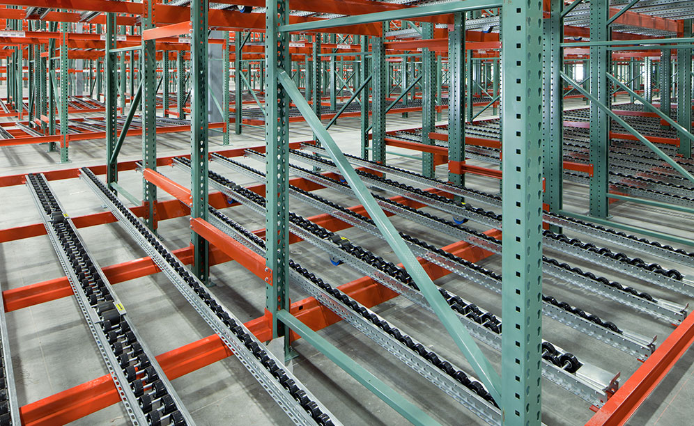 The racking features wheel track sections installed on a sloped lane, and the pallets flow from the entry side to the picking side, creating a first in, first out (FIFO) system