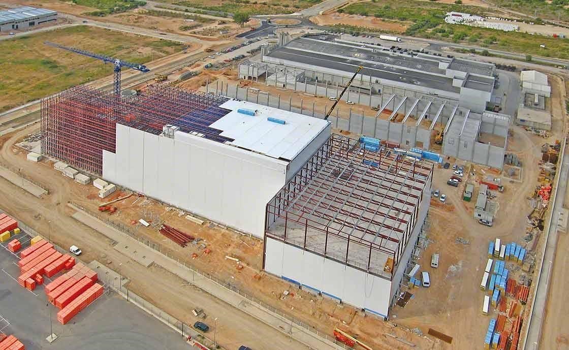 Warehouse construction with integral rack-supported systems, prepared to withstand earthquakes or strong gusting wind.