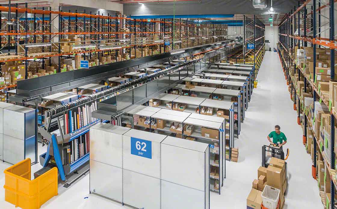 An operator performs warehouse picking tasks, aided by a pallet truck