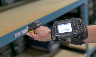 A ring scanner is worn on a worker’s finger and secured with a strap
