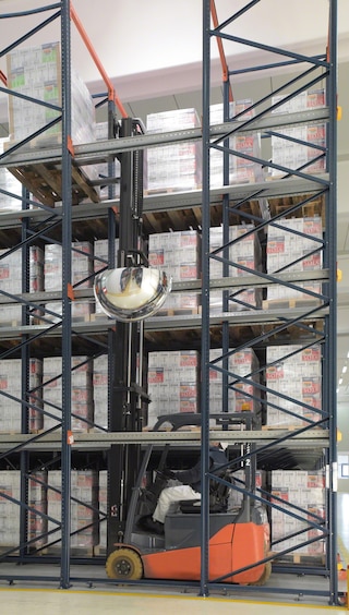 The forklifts travel inside the drive-in rack with the load raised above the level on which it will be deposited