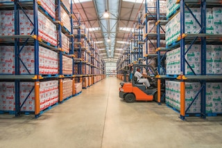 Forklifts enter drive-in racking to load and unload pallets