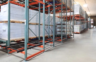 Pallets are deposited on a set of carts that slide along rails